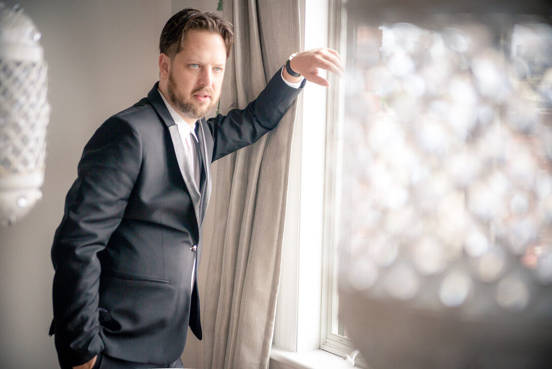 Eshy Gazit portrait — window light, navy suit